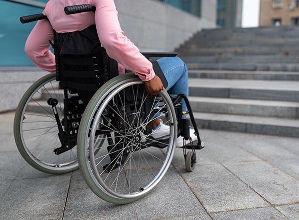 Woman in wheelchair in front of steps